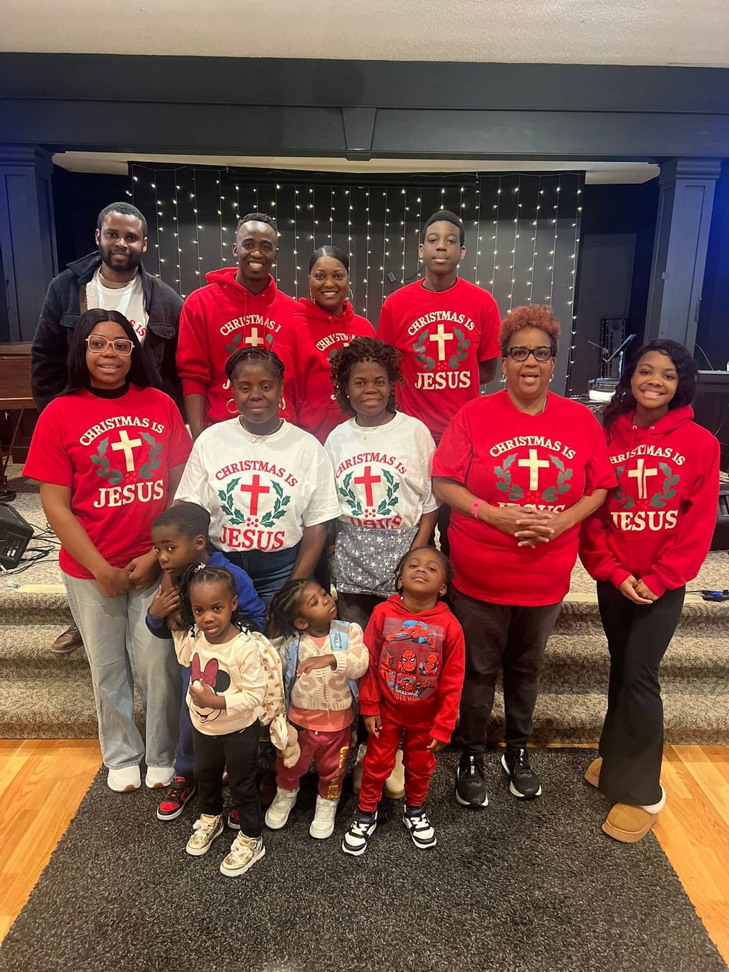 The Romans 116 Church family gathered in matching shirts in the sanctuary.